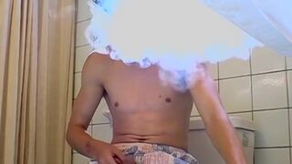 Stud gay Ian Madrox lights up cigar and tugs cock with hand